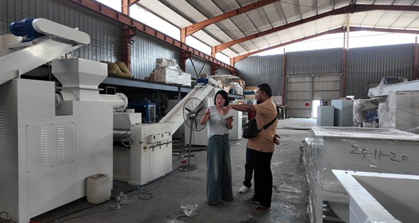 Client visite l'atelier pour examiner la machine de fabrication de savon