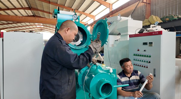 Technicien réglant la machine de production de savon dans l'atelier d'usine